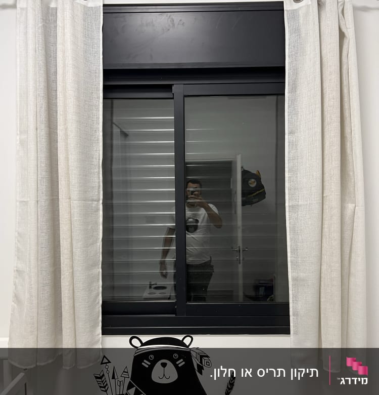 חלון עם תריסים סגורים ומסגרת שחורה